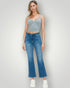 Woman wearing a gray tank top and blue jeans on a white background