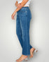 Person wearing blue jeans on a plain background