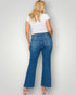Person wearing blue jeans and a white t-shirt on a plain background