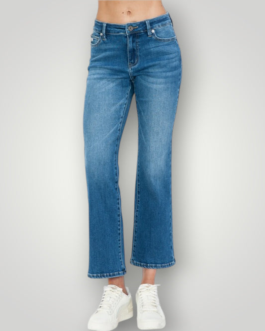 Blue jeans worn by a person on a plain background