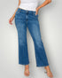 Person wearing blue jeans and a white top on a plain background