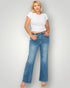 Woman wearing a white t-shirt and blue jeans against a plain background