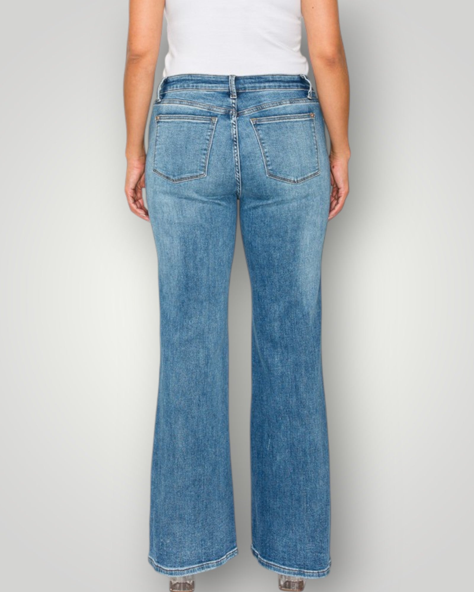 Person wearing blue jeans on a plain background