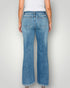 Person wearing blue jeans on a plain background