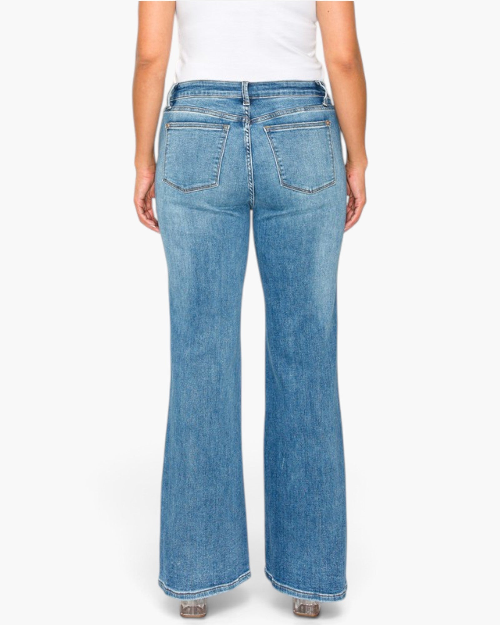 Rear view of a model wearing light blue wide-leg denim jeans with a white top, shown against a plain white studio background.