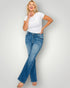 Woman wearing a white t-shirt and blue jeans on a plain background