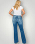 Person wearing blue jeans and a white t-shirt against a plain background