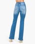 Rear view of a model wearing blue flare jeans with a faded wash and gold high heels, set against a plain white background.