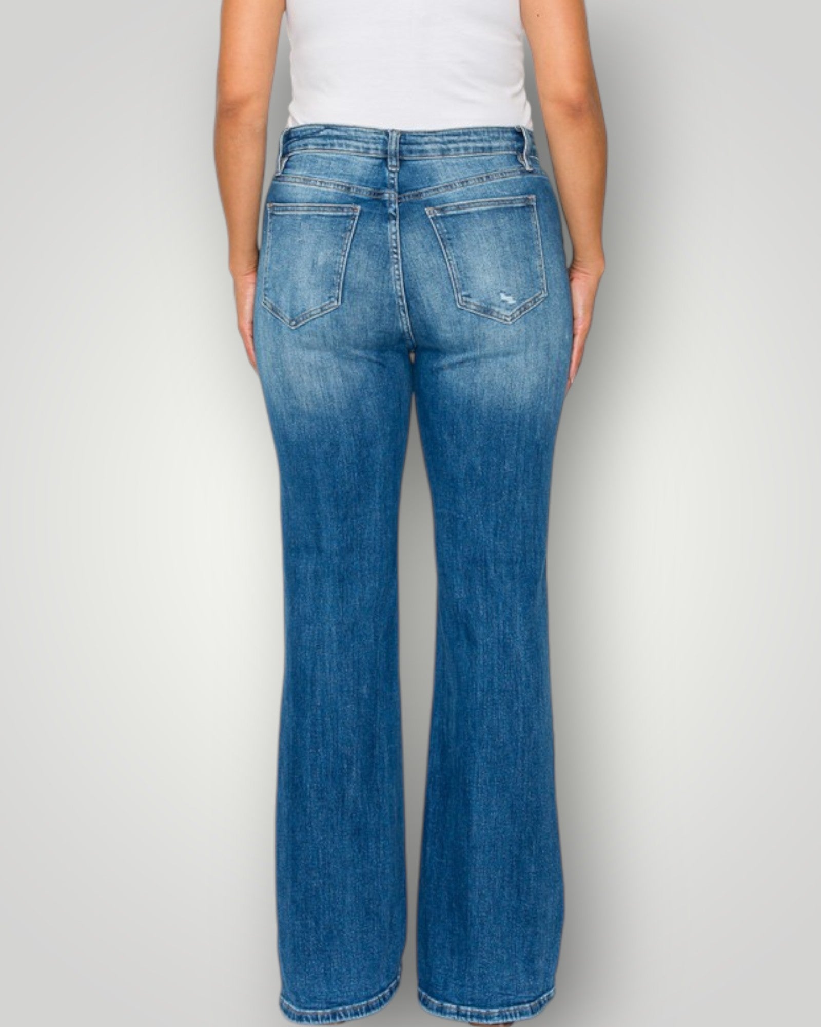 Person wearing blue jeans on a plain background