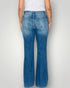 Person wearing blue jeans on a plain background