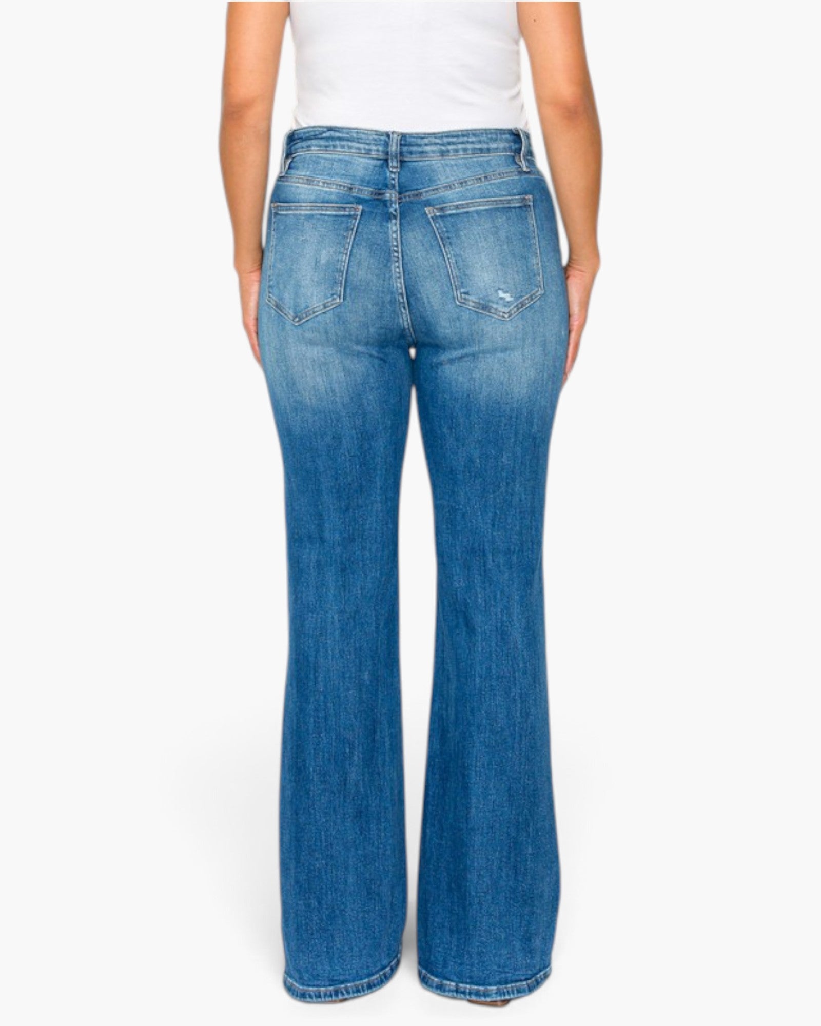 A person shown from the back wearing blue wide-leg denim jeans and a white top, photographed against a plain light gray studio background.