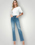 Woman wearing a white t-shirt and blue jeans on a plain background