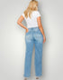 Woman wearing blue jeans and a white t-shirt against a plain background