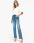 A woman modeling light-wash blue high-rise jeans with distressed details on the thighs and knees, paired with a white t-shirt and clear high-heeled sandals, against a plain white studio background.