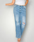 Light blue distressed jeans worn by a person on a plain background
