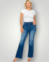 Woman wearing a white t-shirt and blue jeans on a plain background