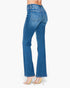 A model shown from the back wearing blue high-waisted flare jeans and clear high-heeled sandals against a plain white background.