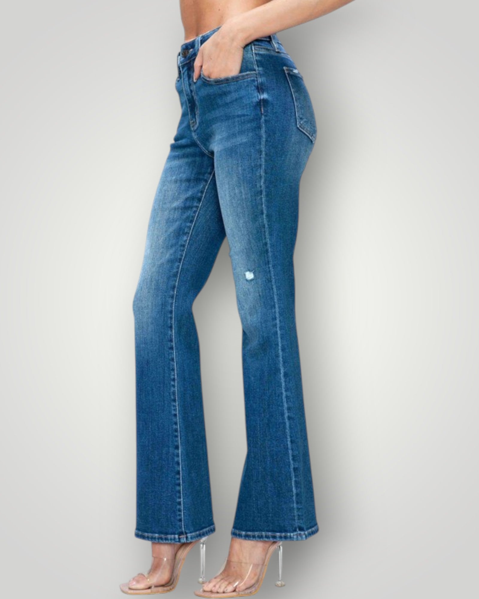 Blue jeans worn by a person on a plain background