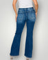 Person wearing blue flared jeans on a plain background