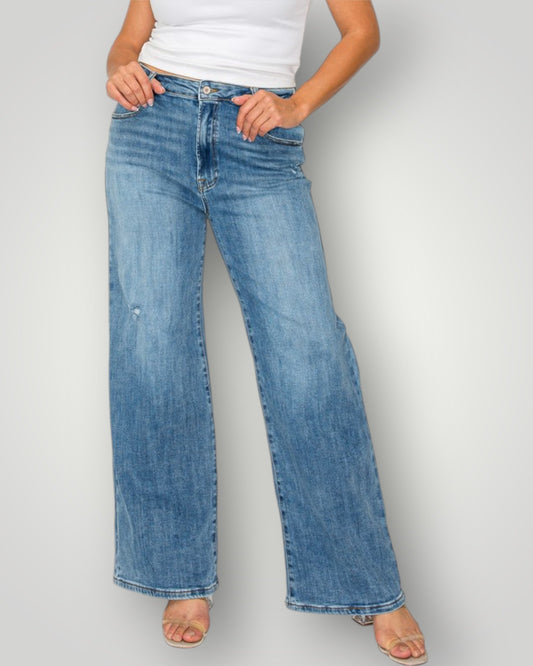 Person wearing light blue jeans on a plain background