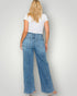 Person wearing blue jeans and a white t-shirt on a plain background