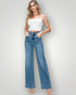 Woman wearing a white top and blue jeans on a plain background