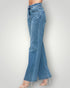 Blue jeans worn by a person on a plain background