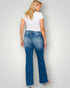 Woman wearing blue jeans and a white t-shirt against a plain background