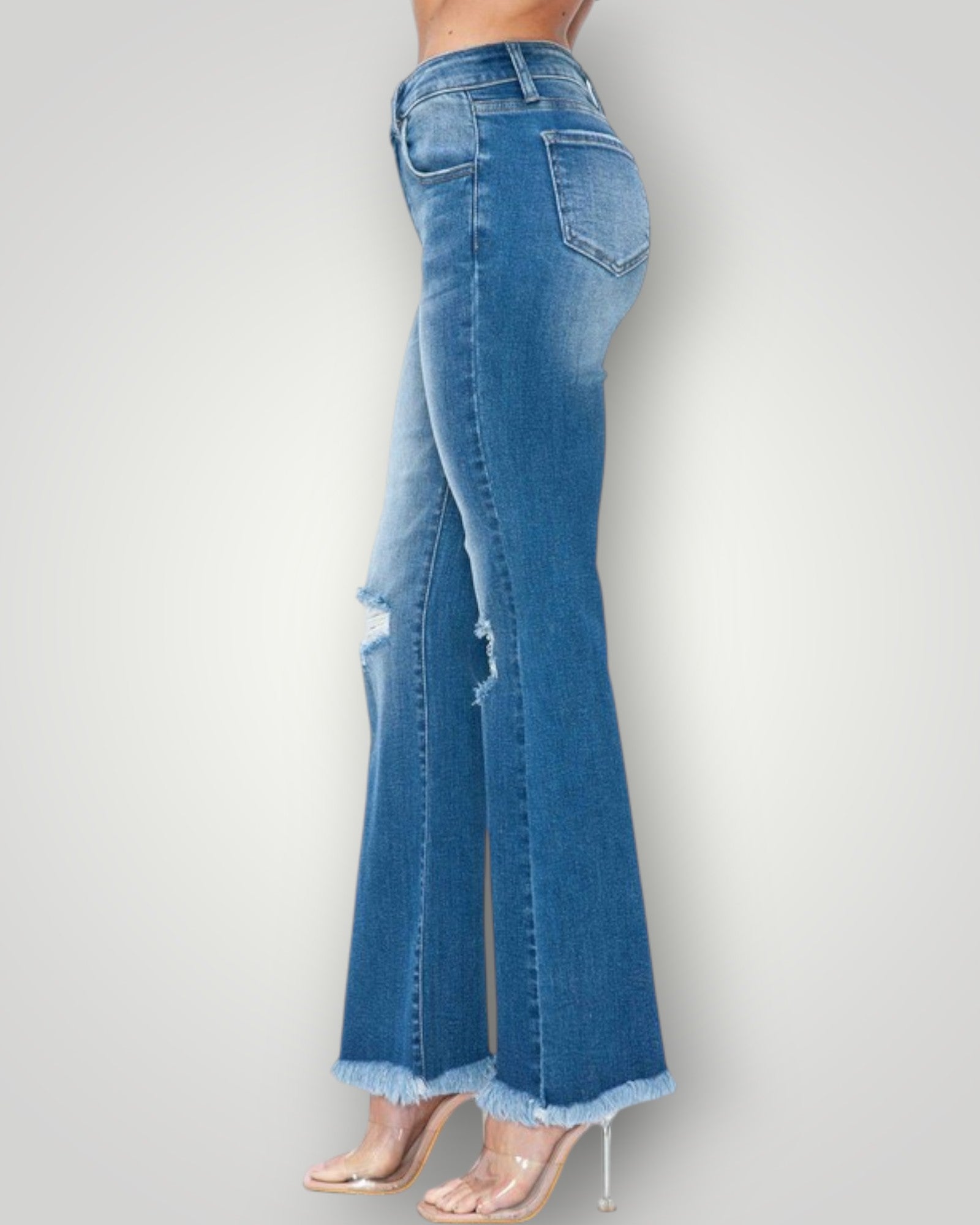 Blue jeans with a frayed hem on a white background