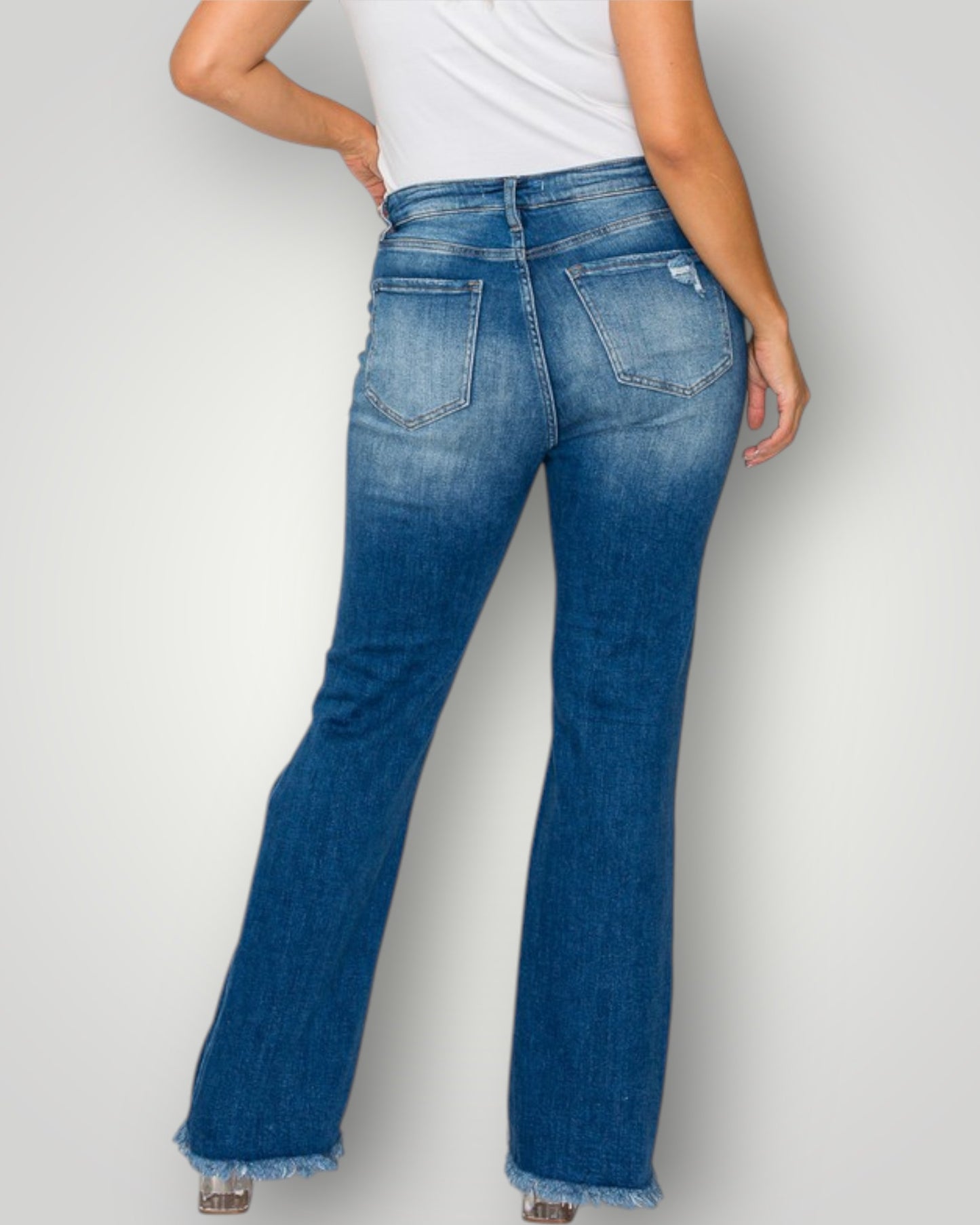 Blue flared jeans worn by a person on a light gray background