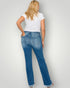 Woman wearing blue jeans and a white t-shirt on a plain background