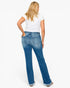 A woman shown from the back wearing blue denim jeans, a white t-shirt, and brown sandals against a plain white studio background.