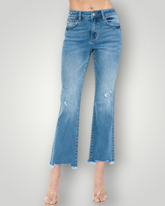 Blue jeans with a distressed look on a gray background