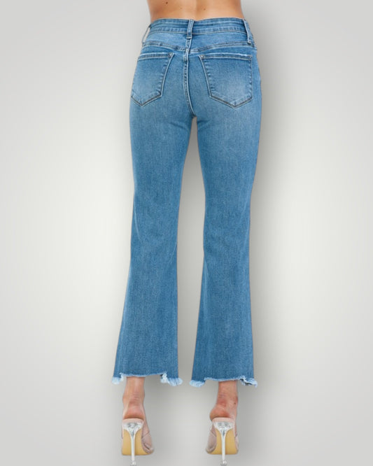 Blue jeans worn by a person on a plain background