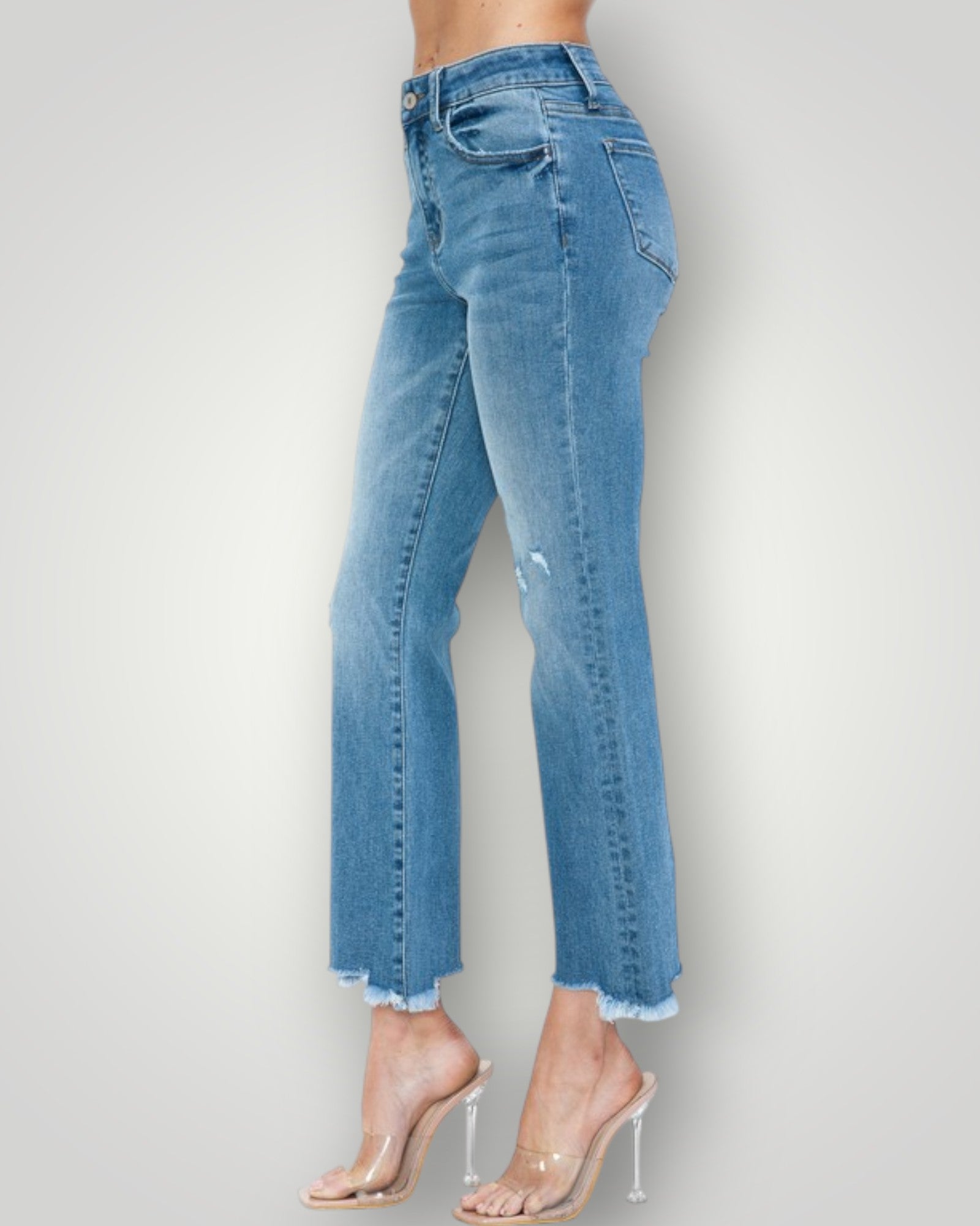 Blue jeans worn by a person on a plain background