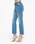 A model's lower body wearing light blue cropped jeans with a raw frayed hem and subtle distressing, paired with clear high-heeled sandals against a plain white background.
