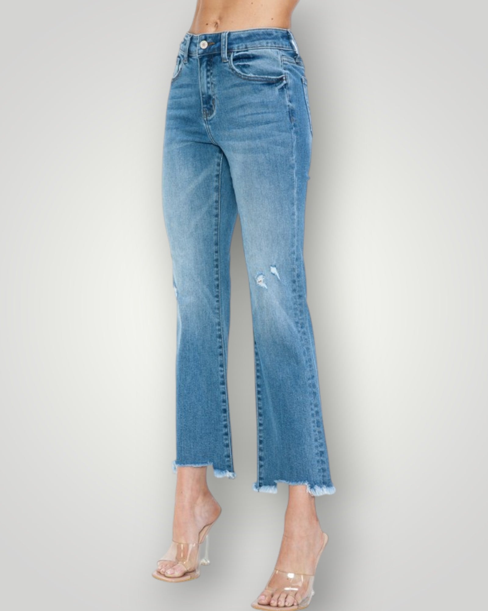 Blue jeans worn by a person on a plain background
