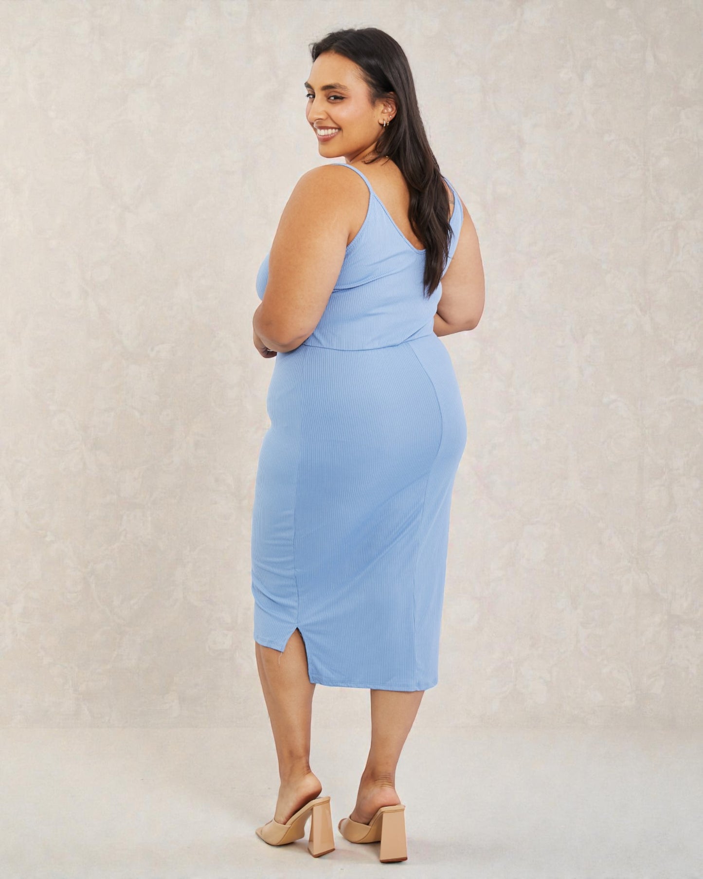 Woman wearing a light blue dress against a plain background