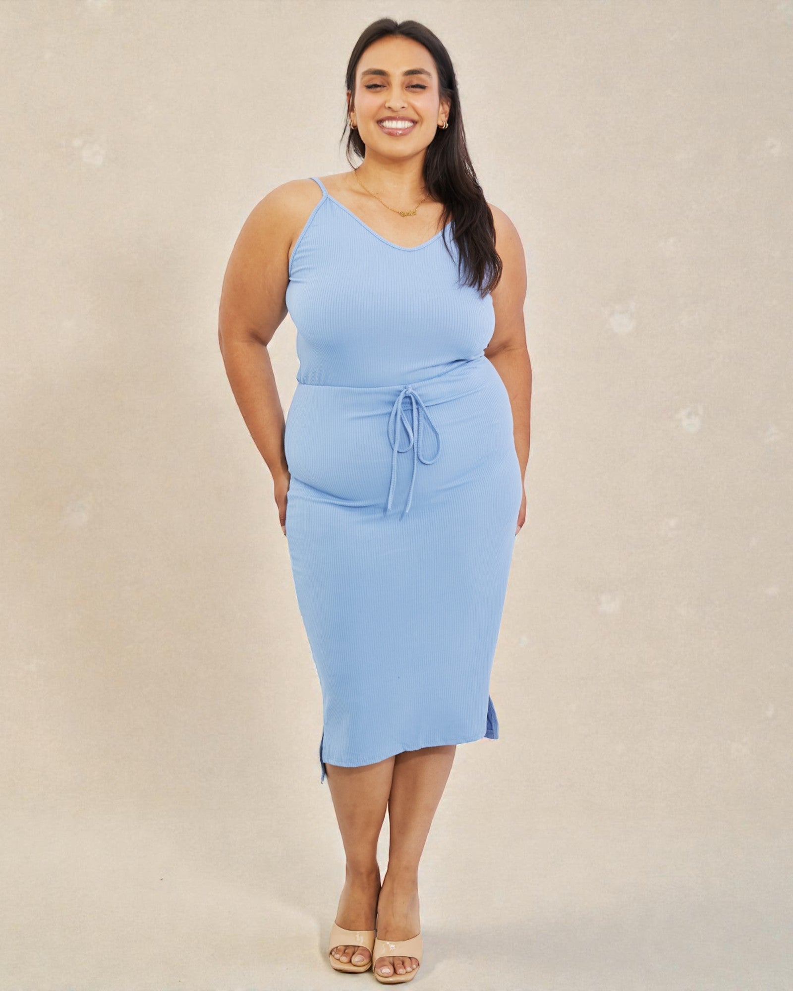 Woman wearing a light blue dress against a beige background