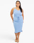 A woman modeling a light blue sleeveless midi dress with a V-neckline, side tie detail, and side slits, paired with beige heeled sandals against a plain white studio background.