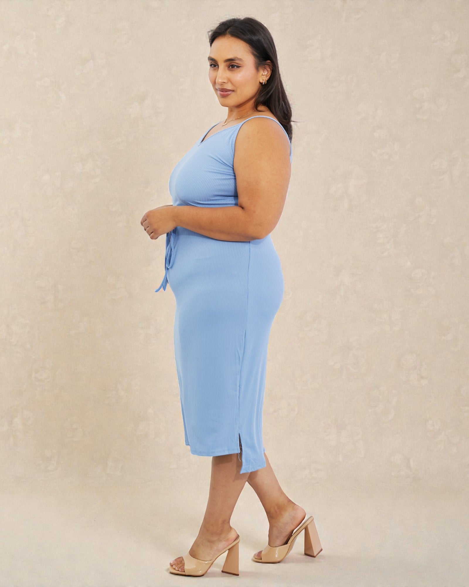 Woman wearing a light blue dress with a beige background