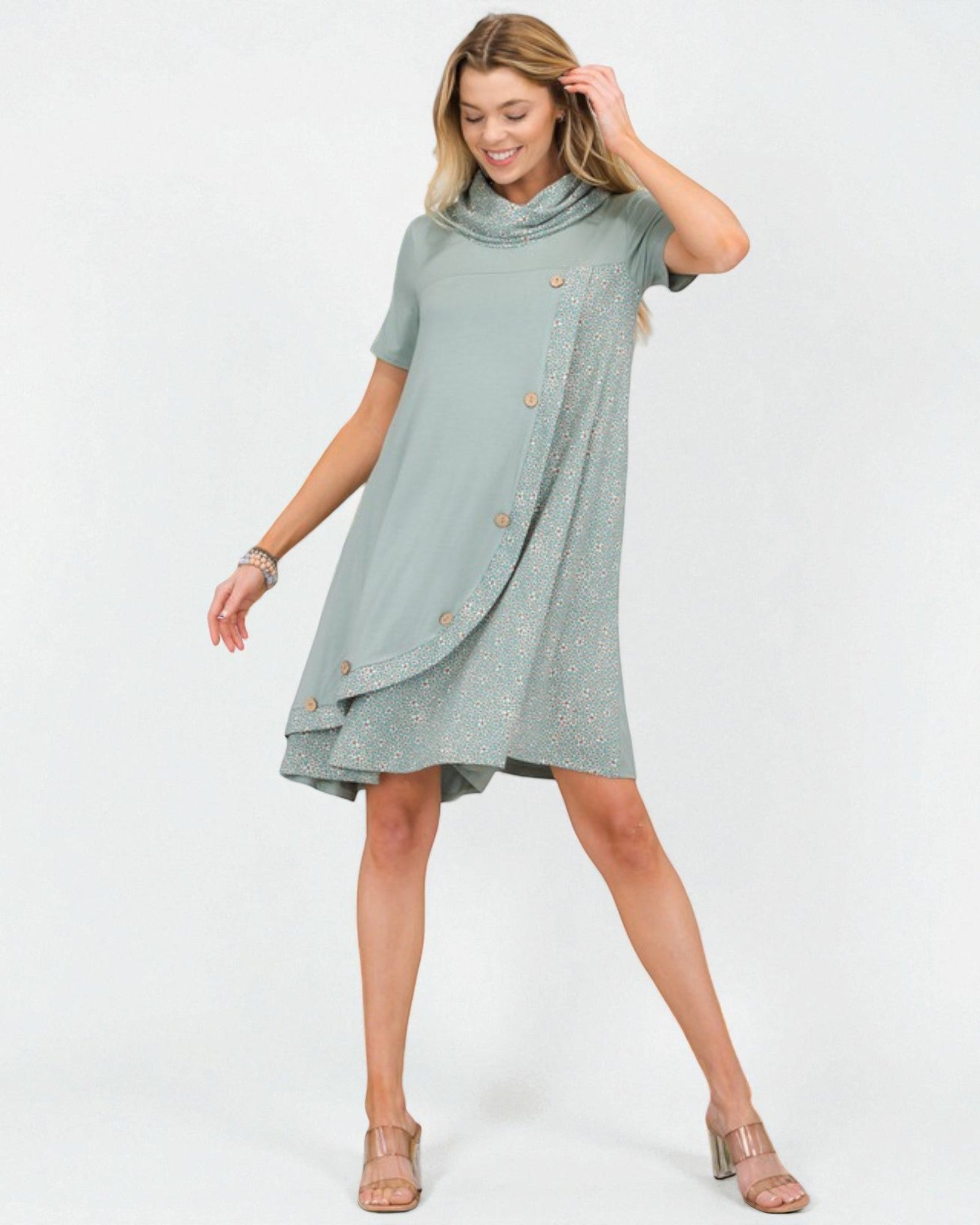 Woman wearing a light green dress with buttons on a white background