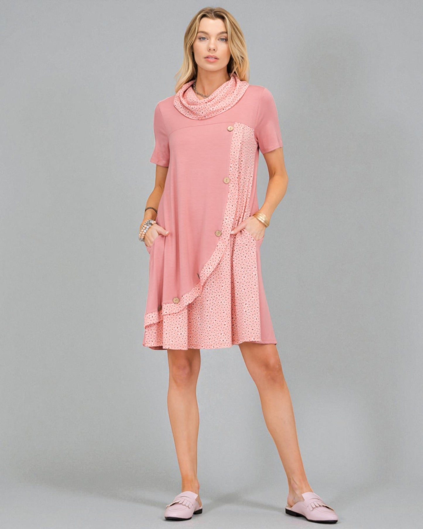 Woman wearing a pink dress with a patterned overlay on a gray background