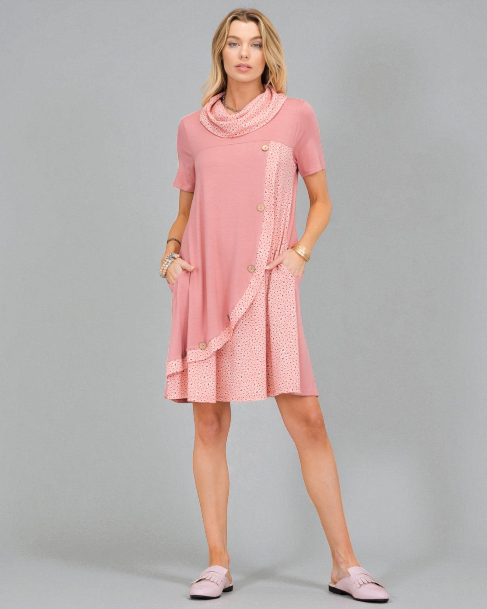 Woman wearing a pink dress with a patterned overlay on a gray background