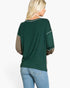 A woman shown from the back wearing a dark green long-sleeve top with contrasting tan sleeves and light blue jeans, against a plain white background.