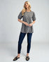 Woman wearing a checkered top and blue jeans on a white background
