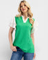 Woman wearing a green and white top with blue jeans on a white background