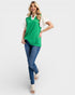 Woman wearing a green and white top with blue jeans on a white background