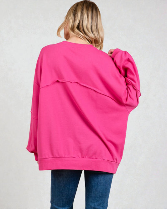 Person wearing a bright pink sweatshirt on a plain background