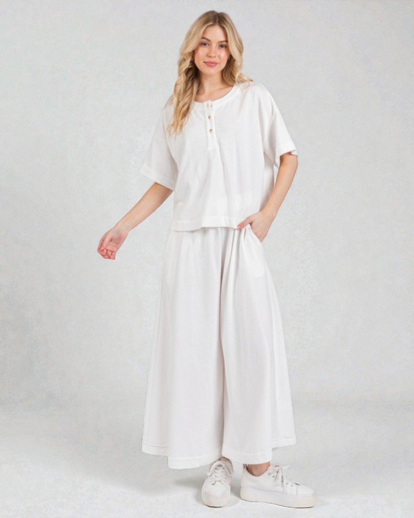 Woman wearing a white outfit on a plain background